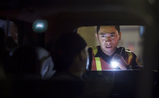 Officer Kevin Millan, from the City of Miami Beach police department, conducts a field sobriety test at a DUI traffic checkpoint.